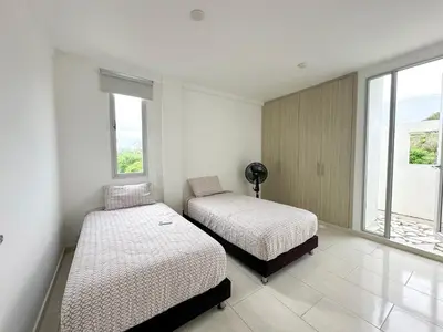 two beds in a room with two windows at Villa in Sabanilla near the Sea in Maizal