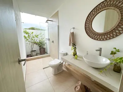 a bathroom with a sink and a toilet and a mirror at Villa in Sabanilla near the Sea in Maizal