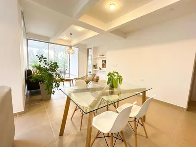 a dining room with a glass table and white chairs at Villa in Sabanilla near the Sea in Maizal
