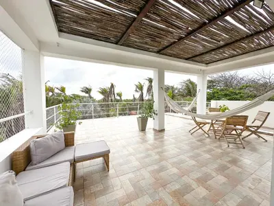 a porch with a hammock and a swing at Villa in Sabanilla near the Sea in Maizal