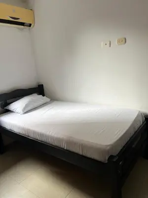 a bed in a room with a white mattress at GUILLO Comfort Loft 2 in Cartagena de Indias