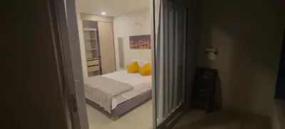 a bedroom with a bed with yellow pillows and a mirror at Santa marina in Santa Marta