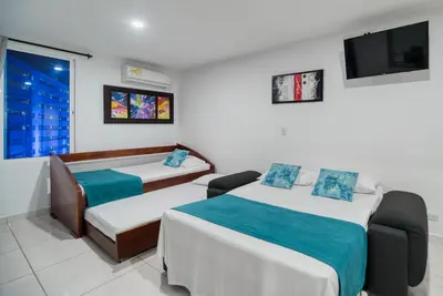 a hotel room with two beds and a tv at Marèlago Apartamentos in Cartagena de Indias