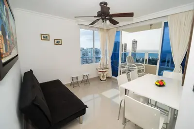 a living room with a ceiling fan and a table and chairs at Marèlago Apartamentos in Cartagena de Indias