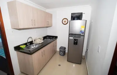a small kitchen with a refrigerator and a sink at Marèlago Apartamentos in Cartagena de Indias
