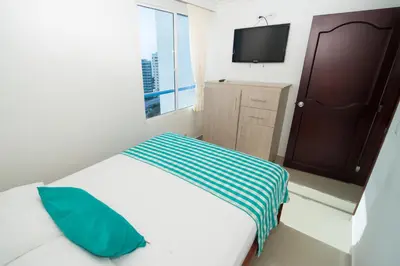 a bedroom with a bed with a television on the wall at Marèlago Apartamentos in Cartagena de Indias