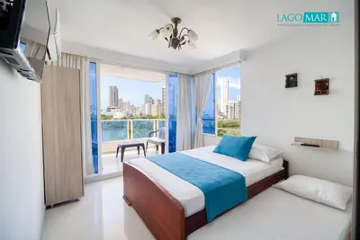 a bedroom with a bed and a large window at Marèlago Apartamentos in Cartagena de Indias