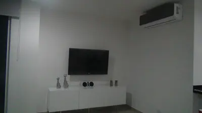 a living room with a flat screen tv on a white wall at Apartamento Los Morros in Cartagena de Indias