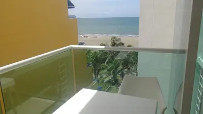 a balcony with a white chair and a view of the beach at Apartamento Los Morros in Cartagena de Indias