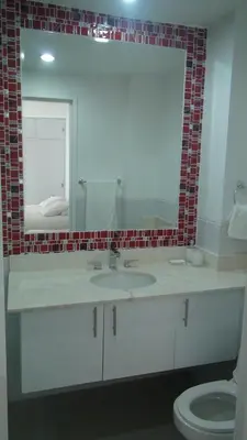 a bathroom with a sink and a mirror and a toilet at Apartamento Los Morros in Cartagena de Indias