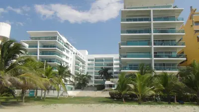 a tall building with palm trees in front of it at Apartamento Los Morros in Cartagena de Indias