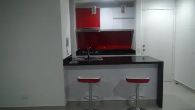 a kitchen with a counter with two stools and a sink at Apartamento Los Morros in Cartagena de Indias
