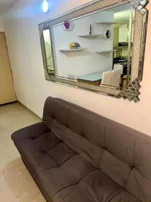 a brown couch in a living room with a mirror at Apartamento moderno in Cartagena de Indias