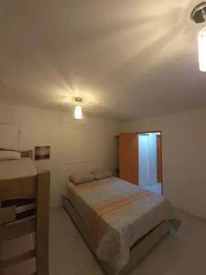 a small bedroom with a bed and a refrigerator at Hermoso apartamento loft en la ciudad amurallada de cartagena 1 in Cartagena de Indias