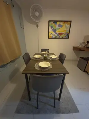 a dining room table with chairs and a wooden table with plates at Hermoso apartamento loft en la ciudad amurallada de cartagena 1 in Cartagena de Indias