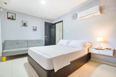 a white bedroom with a bed and a couch at Beautiful House 3 minutes from Historic Downtown in Cartagena de Indias