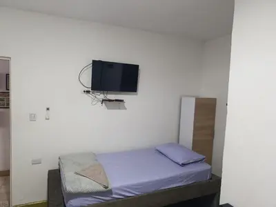 a room with a bed and a tv on a wall at Hostal Mastcoy in Cartagena de Indias