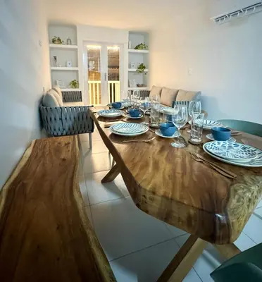 a wooden table with plates and glasses on it at Cozy duplex at Cartagena City Center in Cartagena de Indias