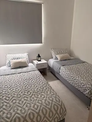 a bedroom with two beds and a night stand with a bedskirts at Brand new apartment near the beach and historic center in Cartagena de Indias