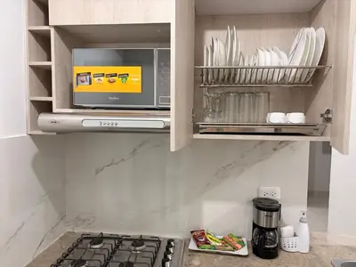 a kitchen with a stove and a microwave at Brand new apartment near the beach and historic center in Cartagena de Indias
