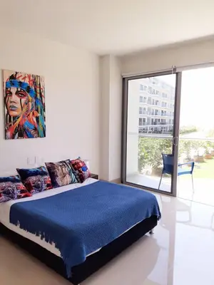 a bedroom with a bed with a painting on the wall at APARTAMENTO MORROS EOS y ECO VISTA AL MAR in Cartagena de Indias