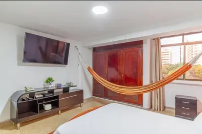 a bedroom with a bed and a hammock in a room at Guest bedrooms economy in Bocagrande Beach Cartagena in Cartagena de Indias