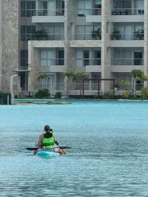 a person in a kayak in the water near a building at Nuevo Penthouse en Baia Kristal con gran terraza in Cartagena de Indias