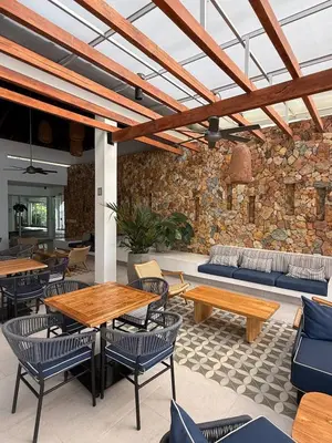 a patio with tables and chairs and a stone wall at Nuevo Penthouse en Baia Kristal con gran terraza in Cartagena de Indias