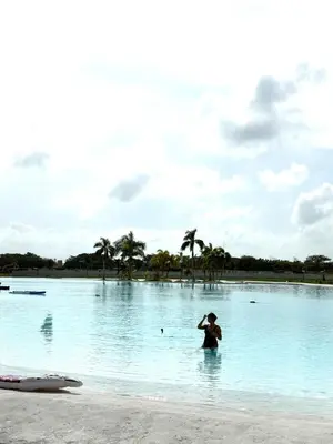 a woman standing in the water on a beach at Nuevo Penthouse en Baia Kristal con gran terraza in Cartagena de Indias