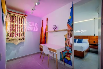a room with a pink room with a table and a bed at Aguita de coco in Cartagena de Indias