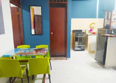 a kitchen with a table and chairs and a blue wall at tranquilo alojamiento centro cartagena in Cartagena de Indias