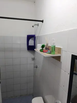 a bathroom with a toilet and a shelf on the wall at Hostal Mastcoy in Cartagena de Indias