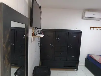 a bedroom with a black dresser and a mirror at Hostal Mastcoy in Cartagena de Indias