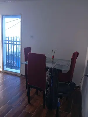 a dining room with a table and chairs and a balcony at Casa vista al mar in Puerto Colombia