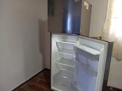an empty refrigerator with its door open in a kitchen at Casa vista al mar in Puerto Colombia