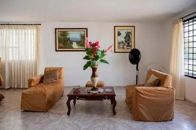 a living room with two chairs and a table with flowers at Charming and relaxing in Manga! Close to Getsemaní in Cartagena de Indias