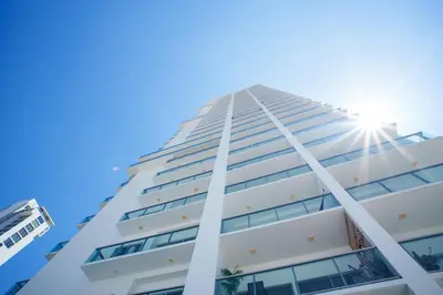 a tall white building with the sun in the sky at I bedroom infinitum view 32nd floor in Cartagena de Indias