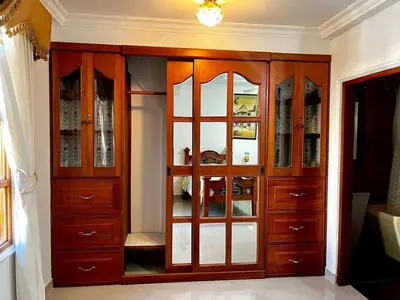 a large wooden cabinet with glass doors in a room at Beautiful Furnished House in CTG in Cartagena de Indias