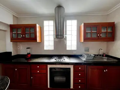 a kitchen with wooden cabinets and a stove top oven at Beautiful Furnished House in CTG in Cartagena de Indias
