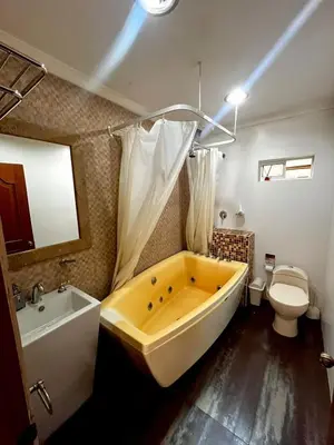 a bathroom with a large tub and a toilet at Beautiful Furnished House in CTG in Cartagena de Indias