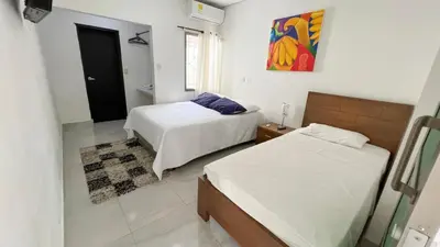a bedroom with two beds and a painting on the wall at Hotel Zoe in Sampués