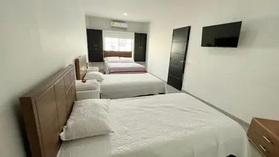 a bedroom with three beds and a flat screen tv at Hotel Zoe in Sampués