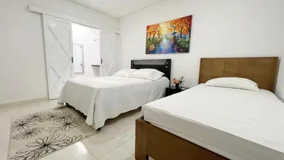 a bedroom with two beds and a painting on the wall at Hotel Zoe in Sampués