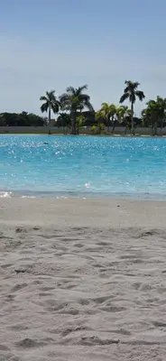 a beach with blue water and palm trees in the background at Baia Kristal Cartagena Kabo 2-3N in Los Arrayanes