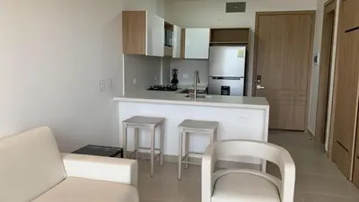 a kitchen with a white counter and stools in a room at Baia Kristal Cartagena Kabo 2-3N in Los Arrayanes