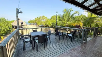 a wooden deck with a table and chairs on it at Cabaña Punta Helvetica in San Antero