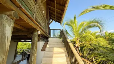 a staircase leading up to a house with palm trees at Cabaña Punta Helvetica in San Antero