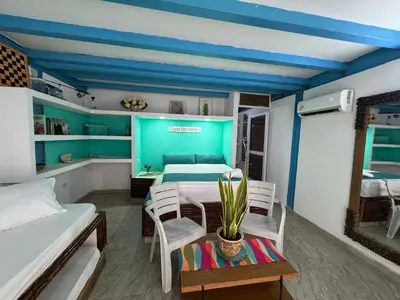 a room with a bed and a table and chairs at Cabaña privada con Jacuzzi a solo un minuto de la playa in Isla de Tierra Bomba