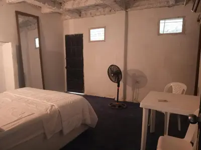 a bedroom with a bed and a desk and a fan at Casa Solangel in Cartagena de Indias