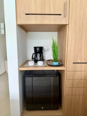 a black coffee maker in a cabinet with a plant at Comfort and Lagoon View at Baia Kristal Cartagena in Los Arrayanes